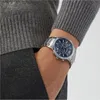 A man's wrist wearing a silver Emporio Armani watch with a blue face. Náhľad obrázku produktu