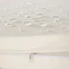 Close-up of water droplets on a cream-colored fabric surface, with a zipper visible below. Náhled obrázku produktu