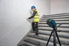 A construction worker is using a laser level on a staircase. Náhľad obrázku produktu