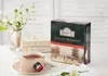A cup of tea with a box of Ahmad Tea English Breakfast in the background, along with some books and flowers. Anteprima dell’immagine prodotto