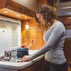 A woman is cooking in a small kitchen, likely in an RV or camper. Náhľad obrázku produktu