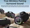 Multiple black portable speakers with colorful LED lights are arranged on a rocky surface. Produktbild-Vorschau
