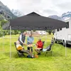 Four people are sitting around a table under a gray canopy tent, with a camper van and mountains in the background. Náhled obrázku produktu