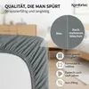 A close-up of a grey fitted sheet with text and icons highlighting its quality and features. Produktbild-Vorschau