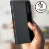 A hand holding a black smartphone case with a transparent window. Voir les images du produit
