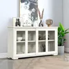 A white sideboard with glass doors is displayed in a room with a painting and plants. Podgląd zdjęcia produktu