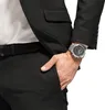 Close-up of a man wearing a black suit and a silver watch. Náhled obrázku produktu