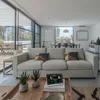 A modern living room with a large sofa, coffee table, and a weather station. Produktbild-Vorschau