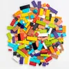 A pile of colorful LEGO bricks is scattered on a white surface. Produktbild-Vorschau