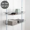 Two wire baskets are mounted on a white telescopic pole, with items stored inside. Produktbild-Vorschau