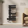 A black electric towel warmer is shown in a modern bathroom setting next to a sofa and a plant. Anteprima dell’immagine prodotto