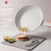 A frying pan is shown tilted, with a fried egg falling from it onto a sandwich. Avocados and greenery are also present on a slate. Anteprima dell’immagine prodotto