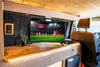 Interior of a van or RV with a TV showing a soccer match, built-in cabinetry, and seating. Produktbild-Vorschau