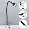 A black LED desk lamp with a flexible gooseneck and a clamp base, shown against a light gray and white background. Insets show close-ups of the lamp head, the clamp mechanism, and the inline switch. Anteprima dell’immagine prodotto