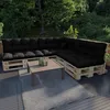 An outdoor patio setting with a sectional sofa made of pallets and black cushions, a coffee table, and a rug. Voir les images du produit