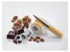 A collection of nuts, chocolate pieces, and a cheese/nut grater on a white background. Produktbild-Vorschau