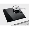 A black induction cooktop with a silver pot and lid on it, set against a white and light gray background. Voir les images du produit