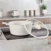 A cream-colored pot with a glass lid sits on a black induction stovetop, with kitchen appliances and canisters in the background. Produktbild-Vorschau