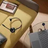 A headset and laptop are placed on a sofa and a glass table. Anteprima dell’immagine prodotto