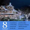 A house decorated with white Christmas lights at night. Produktbild-Vorschau