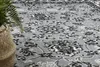 A close-up view of a gray carpet with a floral pattern. Produktbild-Vorschau
