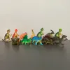 A collection of plastic dinosaur toys arranged on a dark surface against a white and light gray wall. Náhľad obrázku produktu