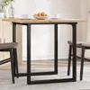A wooden dining table with black metal legs, set with two cups and a bowl of fruit. Anteprima dell’immagine prodotto