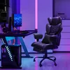 A gaming setup with a computer desk, gaming chair, and computer tower, illuminated by colorful LED lights. Produktbild-Vorschau