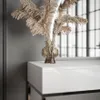 A close-up shot of a modern white vanity table with a glass vase holding dried reeds. Produktbild-Vorschau