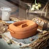 A rustic still life scene featuring a terracotta bread maker, loaf of bread, bag of flour, and wheat stalks. Voir les images du produit