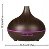 A dark brown aroma diffuser with a wood grain texture and a purple LED light ring around the base. Produktbild-Vorschau