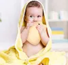 A baby wrapped in a yellow towel is holding a yellow star-shaped toy. Produktbild-Vorschau