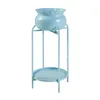 A light blue plant stand with a matching pot and a lower shelf, isolated on a white background. Voir les images du produit