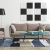 A modern living room with a sofa, coffee table, rug, and wall art. Produktbild-Vorschau