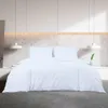A white duvet cover and pillow set on a bed in a modern bedroom. Produktbild-Vorschau