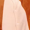 A close-up view of a soft, fuzzy fabric, likely from a child's costume or pajamas, showing two white buttons on a pink panel bordered by brown fabric. Produktbild-Vorschau
