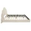 A side view of a beige upholstered bed frame with a scalloped headboard and wooden slats. Produktbild-Vorschau