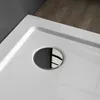 A close-up view of a white shower tray with a chrome drain. Produktbild-Vorschau