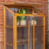 A wooden mini greenhouse with plants inside, placed against a brick wall. Voir les images du produit
