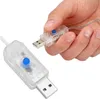 A hand is holding a USB extension cable with a blue button on it, with another similar cable in the foreground. Náhled obrázku produktu