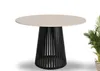A round dining table with a beige top and a black, slatted base, shown in a studio setting with a plant in the background. Náhľad obrázku produktu