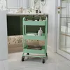 A mint green rolling cart filled with bathroom items, placed in a bathroom setting. Voir les images du produit
