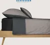 A bed with sheets and pillows, showcasing bedding products. Produktbild-Vorschau