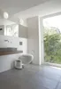 A modern bathroom with a large window overlooking trees. Produktbild-Vorschau