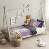 A child's bed with unicorn-themed bedding, decorated with fairy lights and stuffed animals. Náhľad obrázku produktu