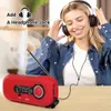A woman is listening to a radio with headphones, with the radio in the foreground. Produktbild-Vorschau