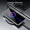 A smartphone in a clear case is wirelessly charging on a charging pad next to a laptop. Náhľad obrázku produktu