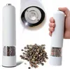 A collage showing an electric pepper grinder, a close-up of its grinding mechanism, a pile of peppercorns, and a hand holding the grinder. Podgląd zdjęcia produktu