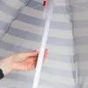 A hand is shown adjusting the pole of a striped umbrella. Produktbild-Vorschau