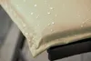 Close-up of a beige cushion with water droplets on it, resting on a black metal frame. Produktbild-Vorschau